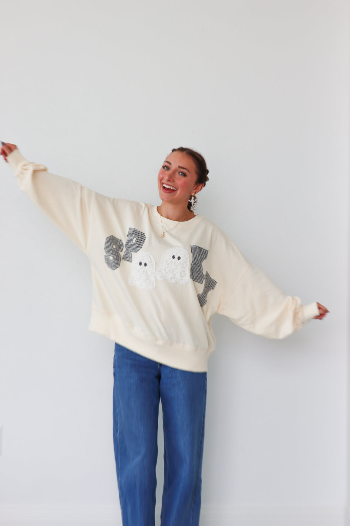 girl wearing cream "spooky" longsleeve top