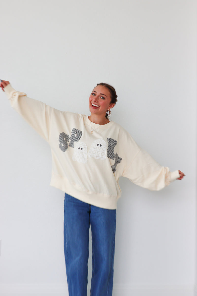 girl wearing cream "spooky" longsleeve top
