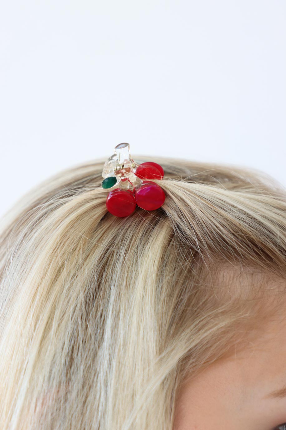 girl wearing small red cherry clip in her hair