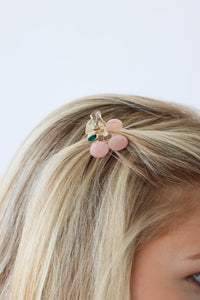 girl wearing small pink cherry clip in her hair