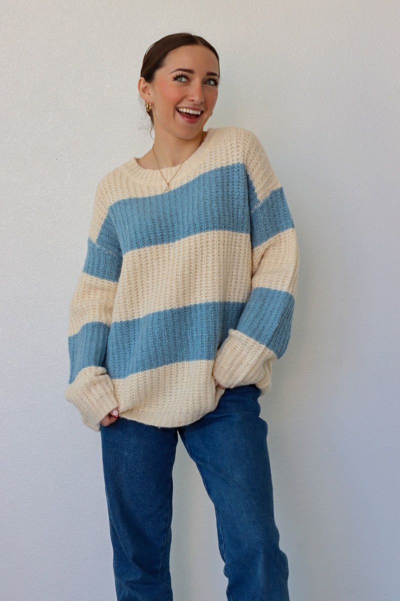 girl wearing blue and cream striped knit sweater