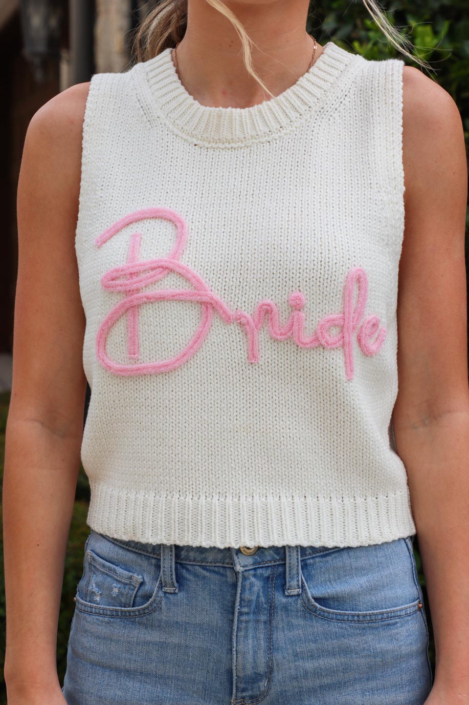 girl wearing white knit tank top with pink "bride" lettering
