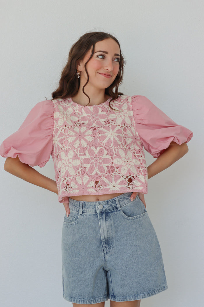 girl wearing pink puff sleeved top with crochet detailing