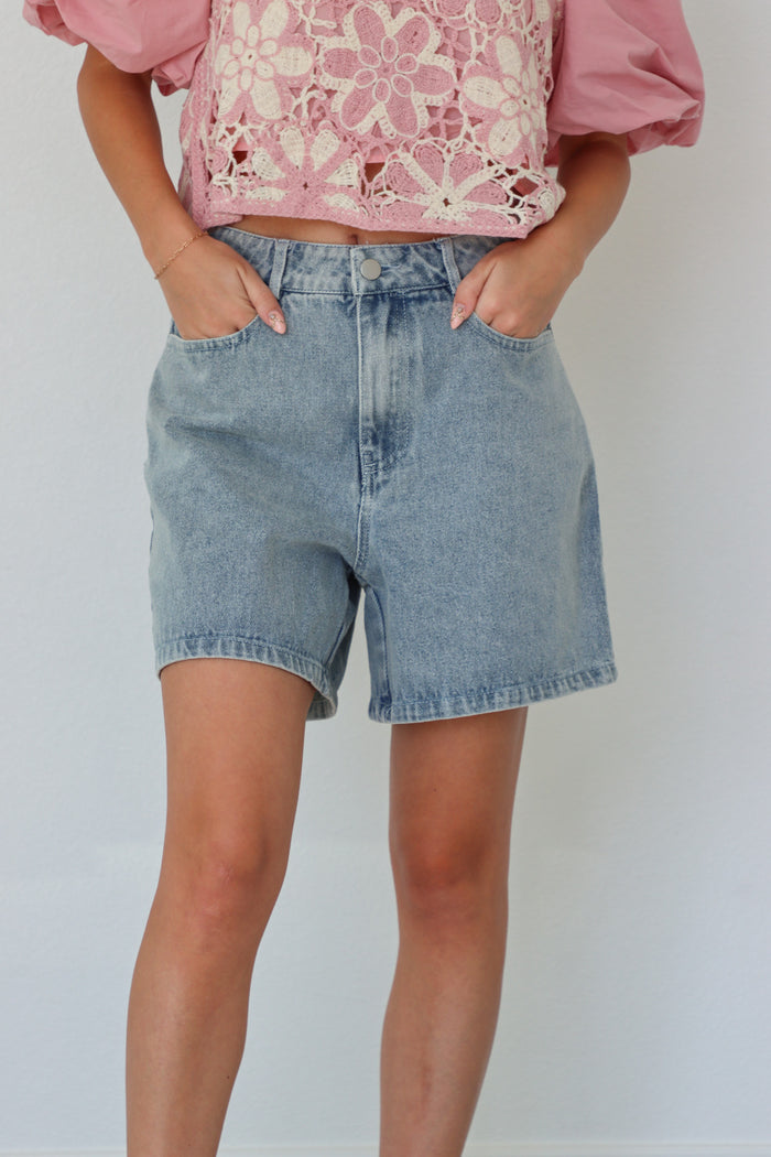 girl wearing light wash loose denim shorts