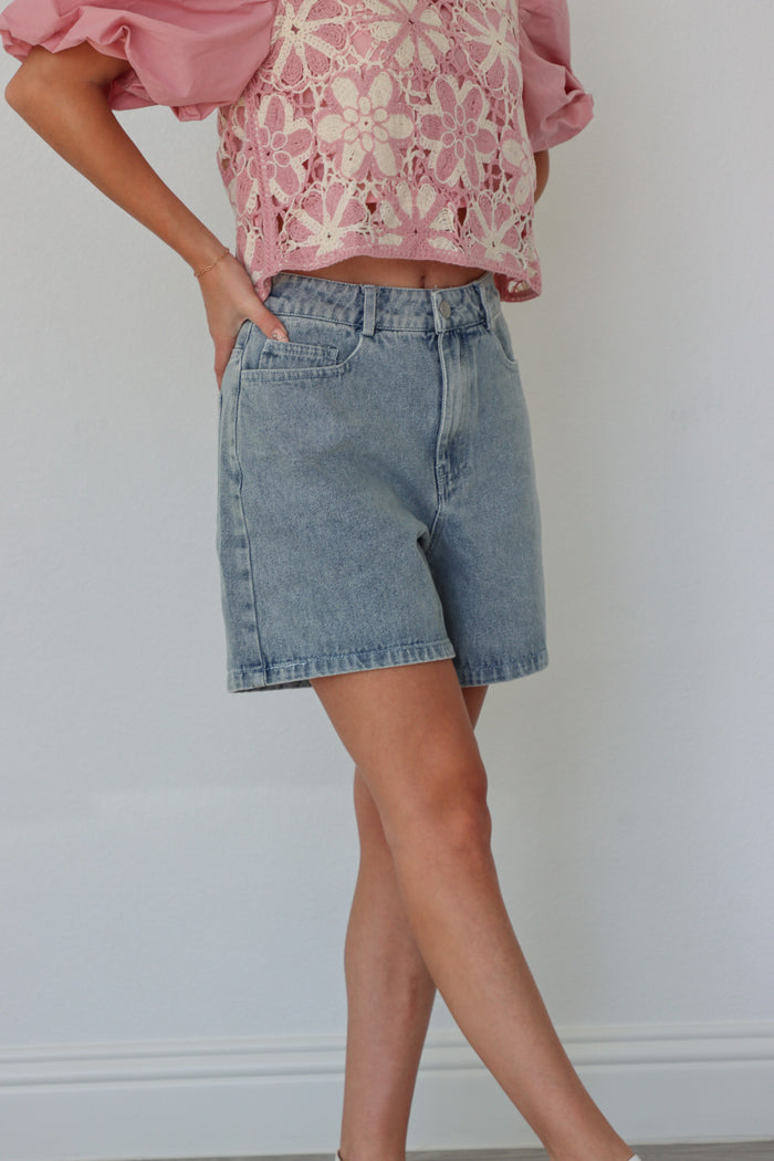 girl wearing light wash loose denim shorts