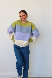 girl wearing blue,green, and cream striped knit sweater