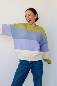 girl wearing blue,green, and cream striped knit sweater