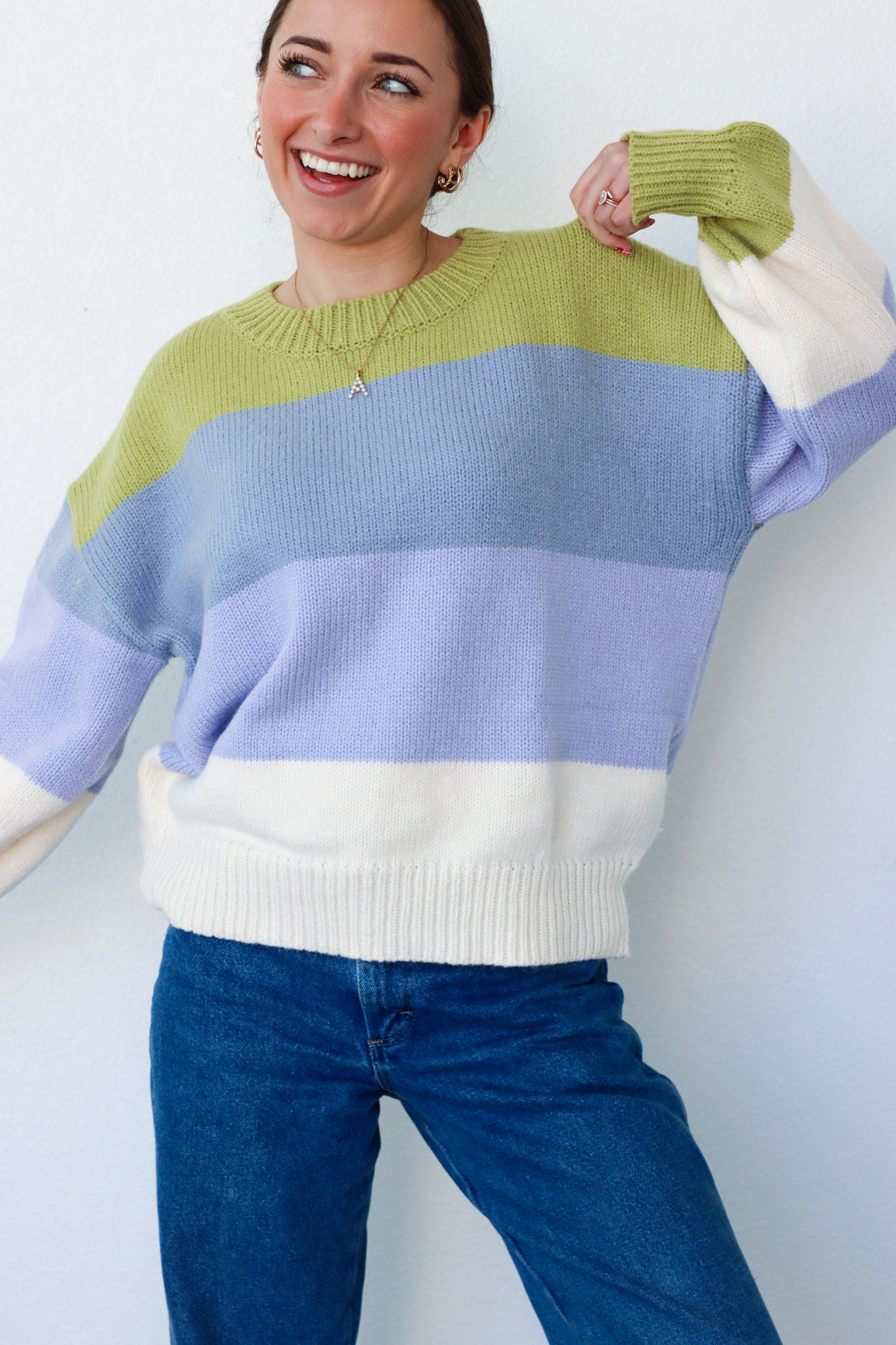 girl wearing blue,green, and cream striped knit sweater