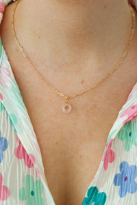 girl wearing pink stone necklace with a gold chain