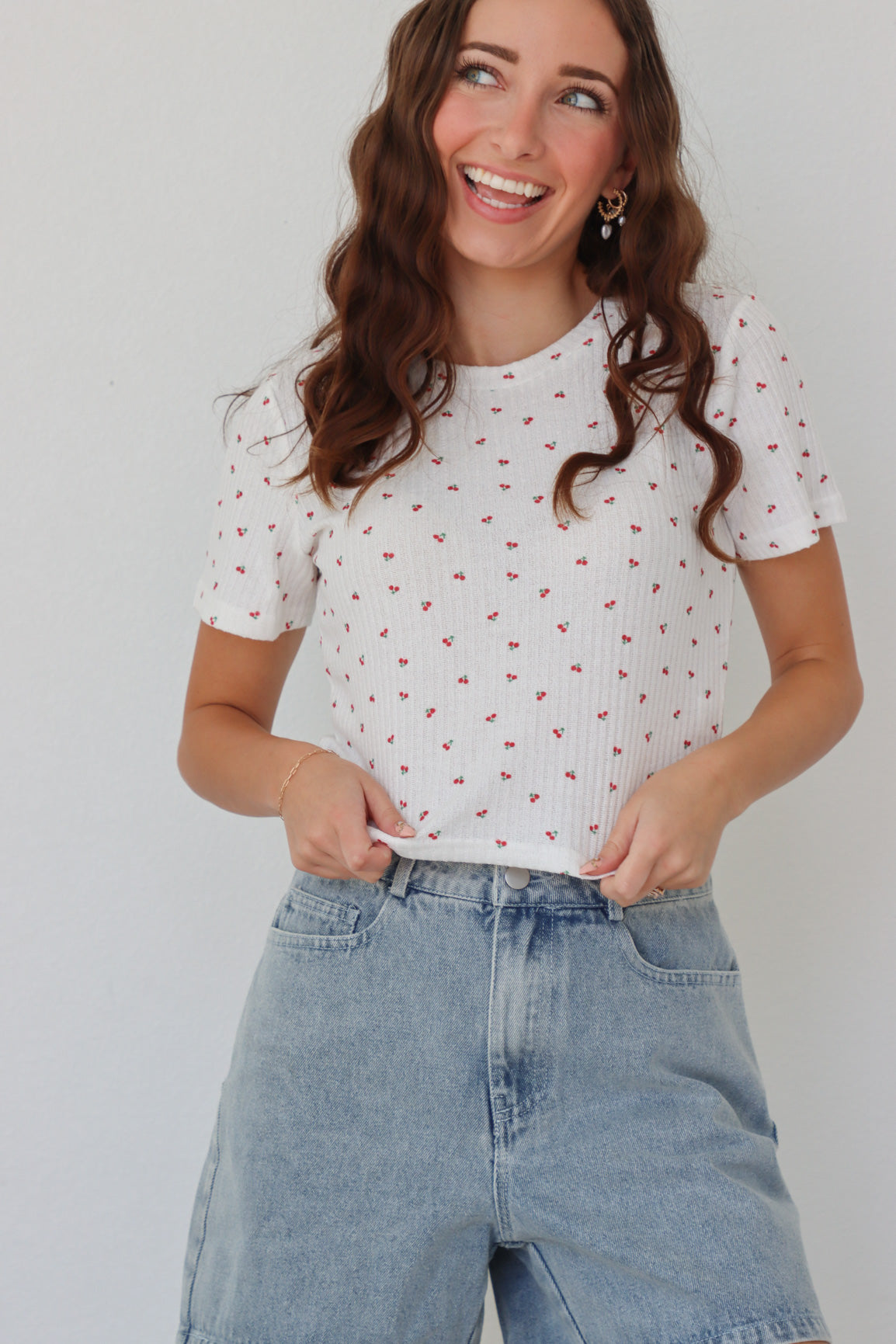 girl wearing white baby tee with cherry pattern