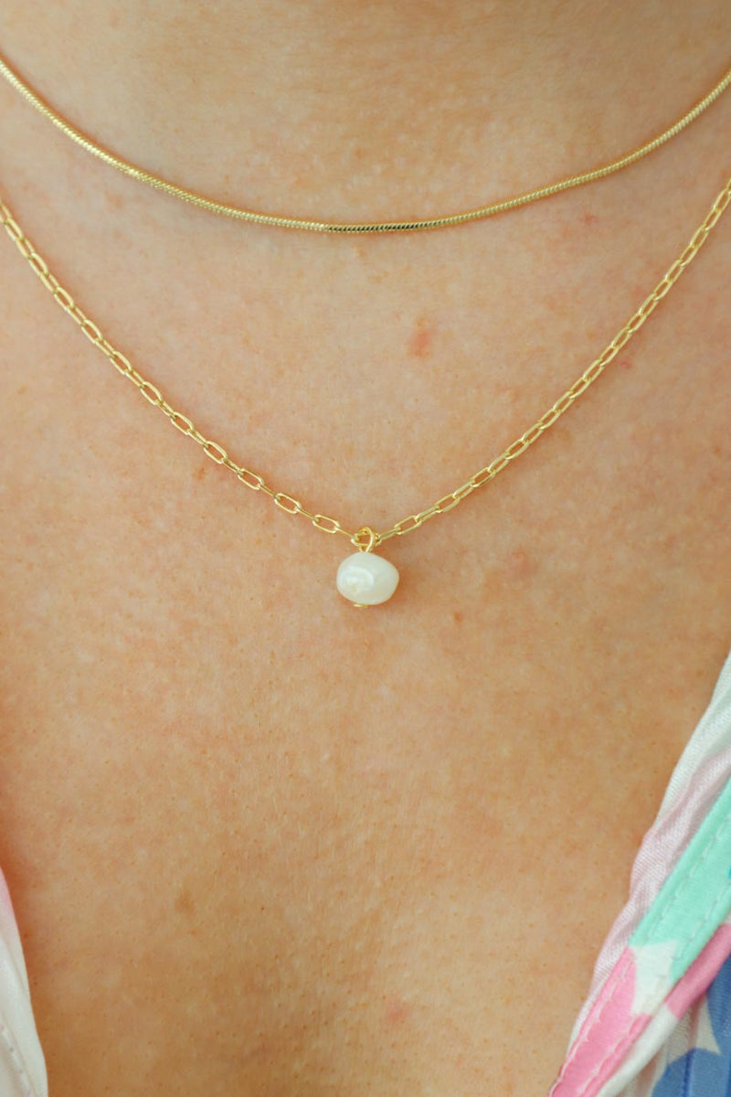 girl wearing gold chain necklace with pearl charm