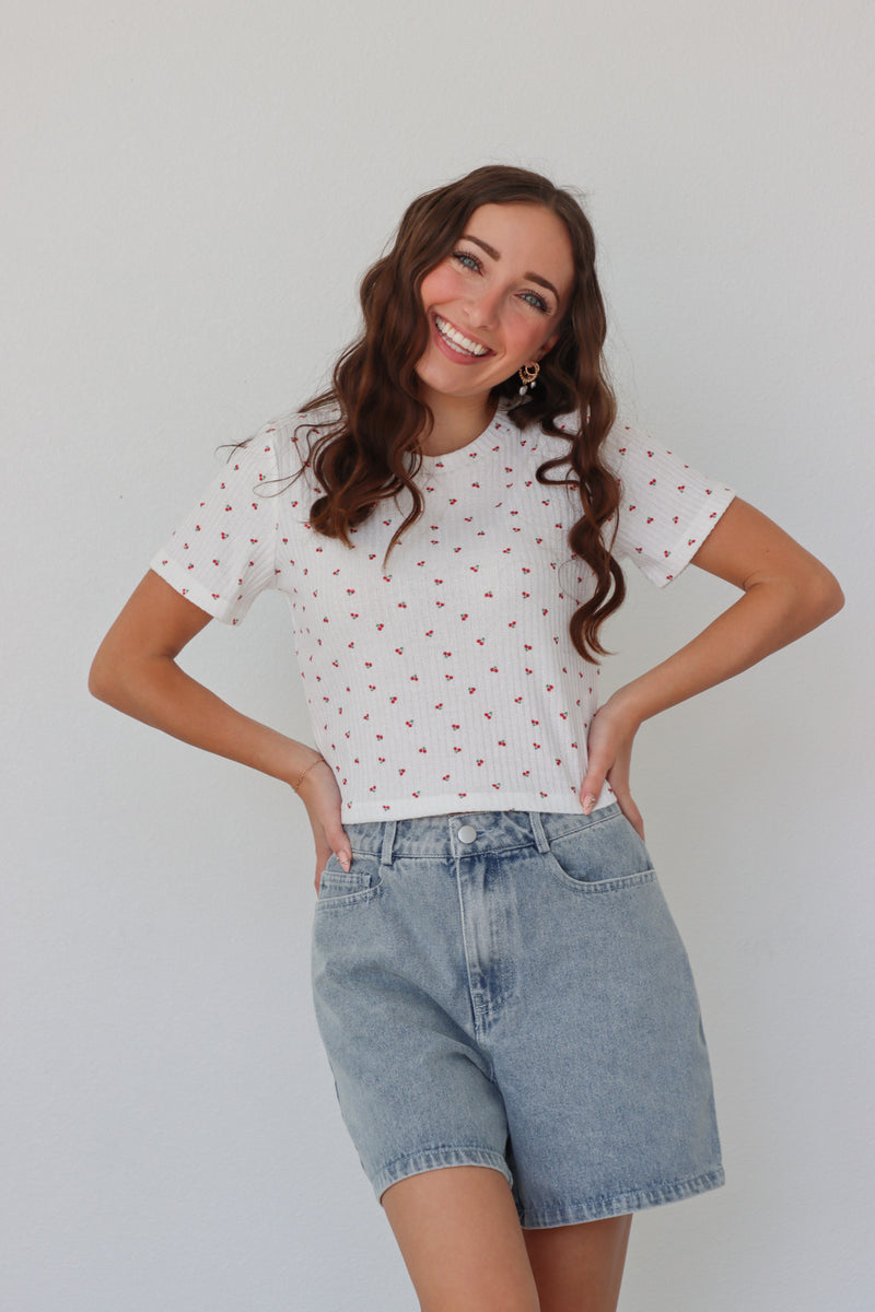 girl wearing white baby tee with cherry pattern