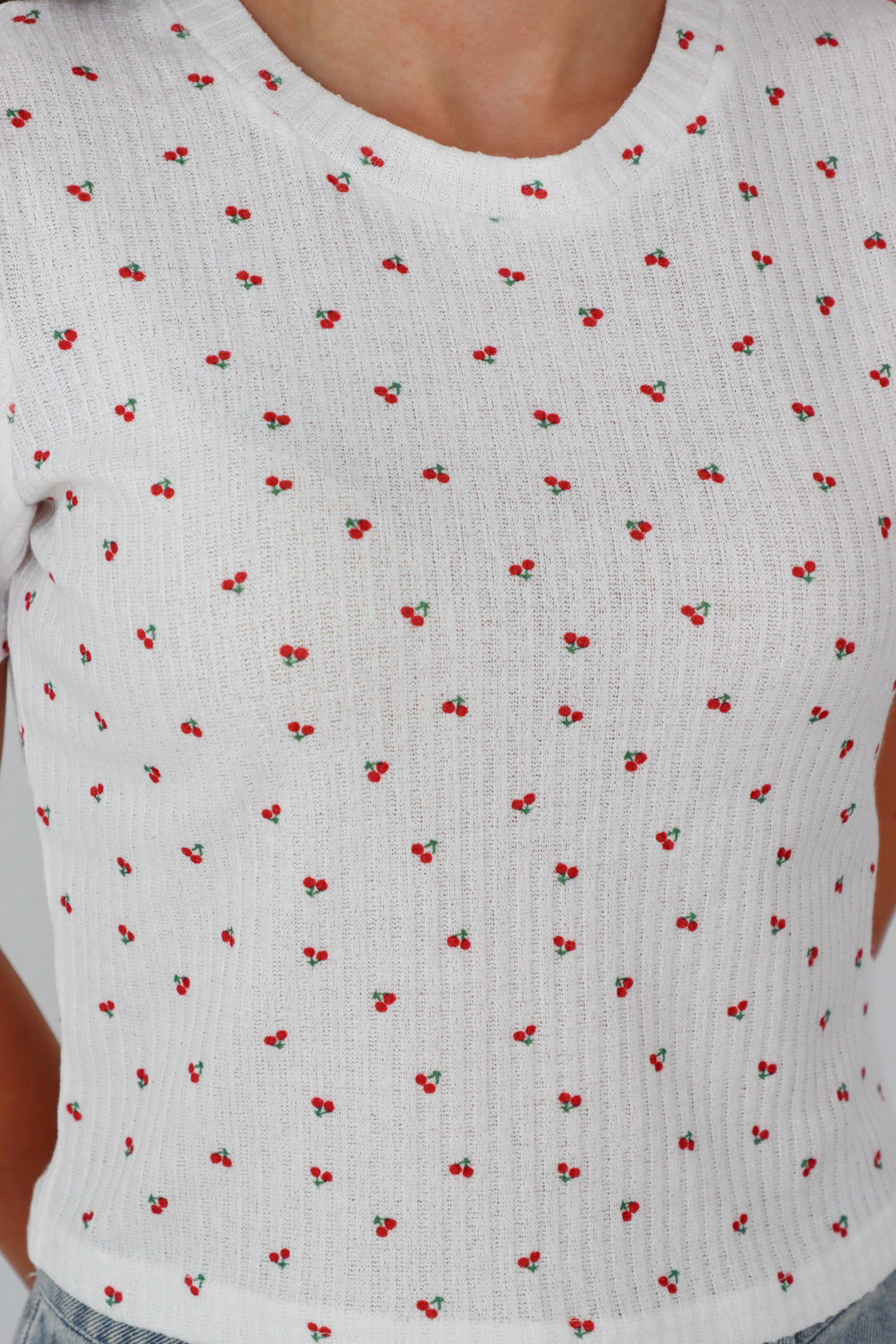 girl wearing white baby tee with cherry pattern