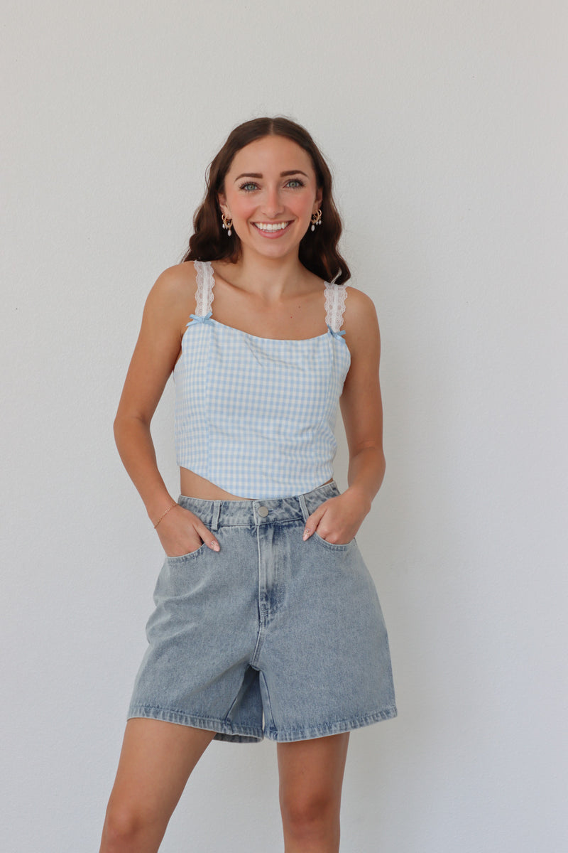 girl wearing blue gingham cropped top with lace sleeves