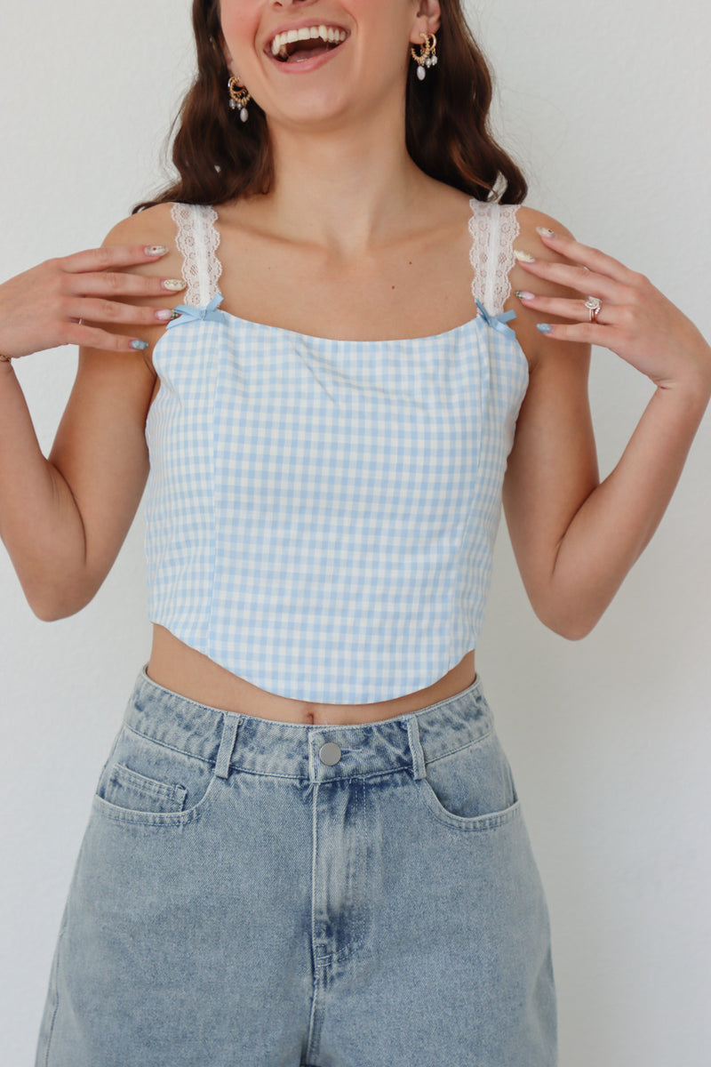 girl wearing blue gingham cropped top with lace sleeves