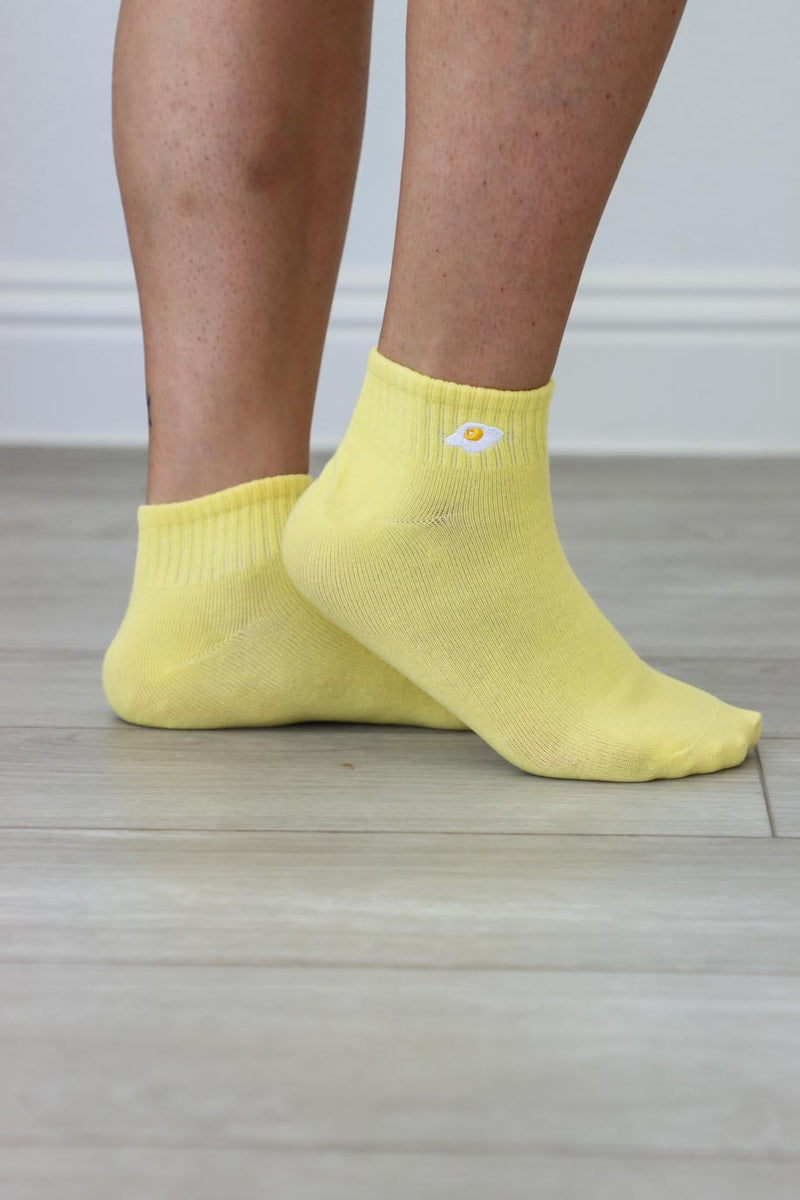girl wearing yellow socks with embroidered egg graphic