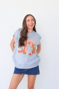 Woman wearing a light blue sweater with a graphic design on a white background