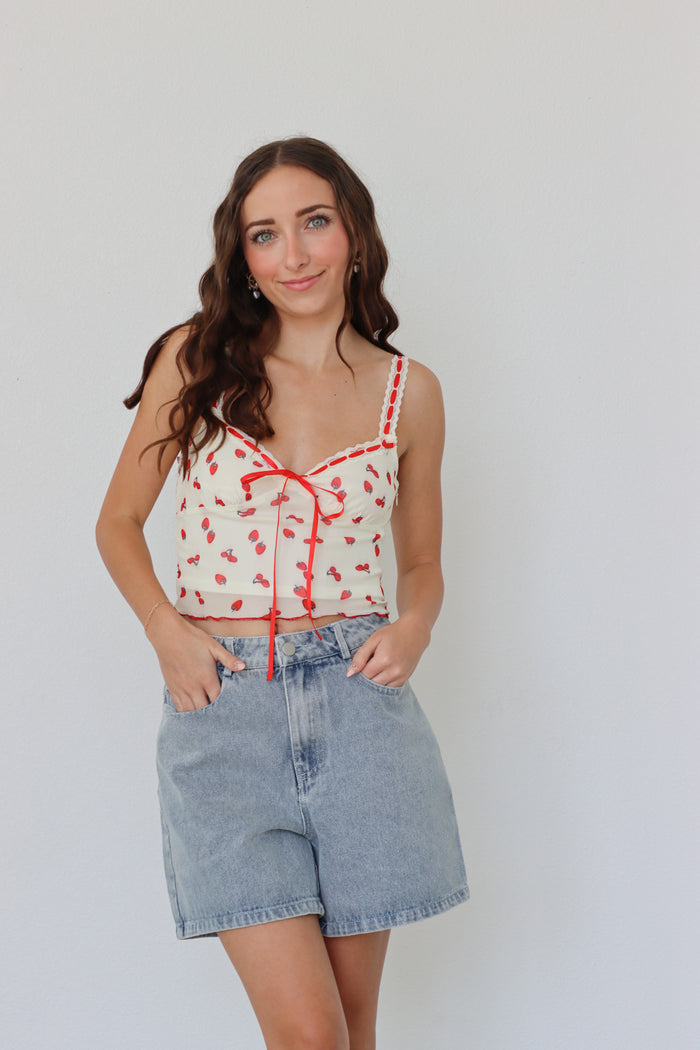 girl wearing cream and red top with strawberry print