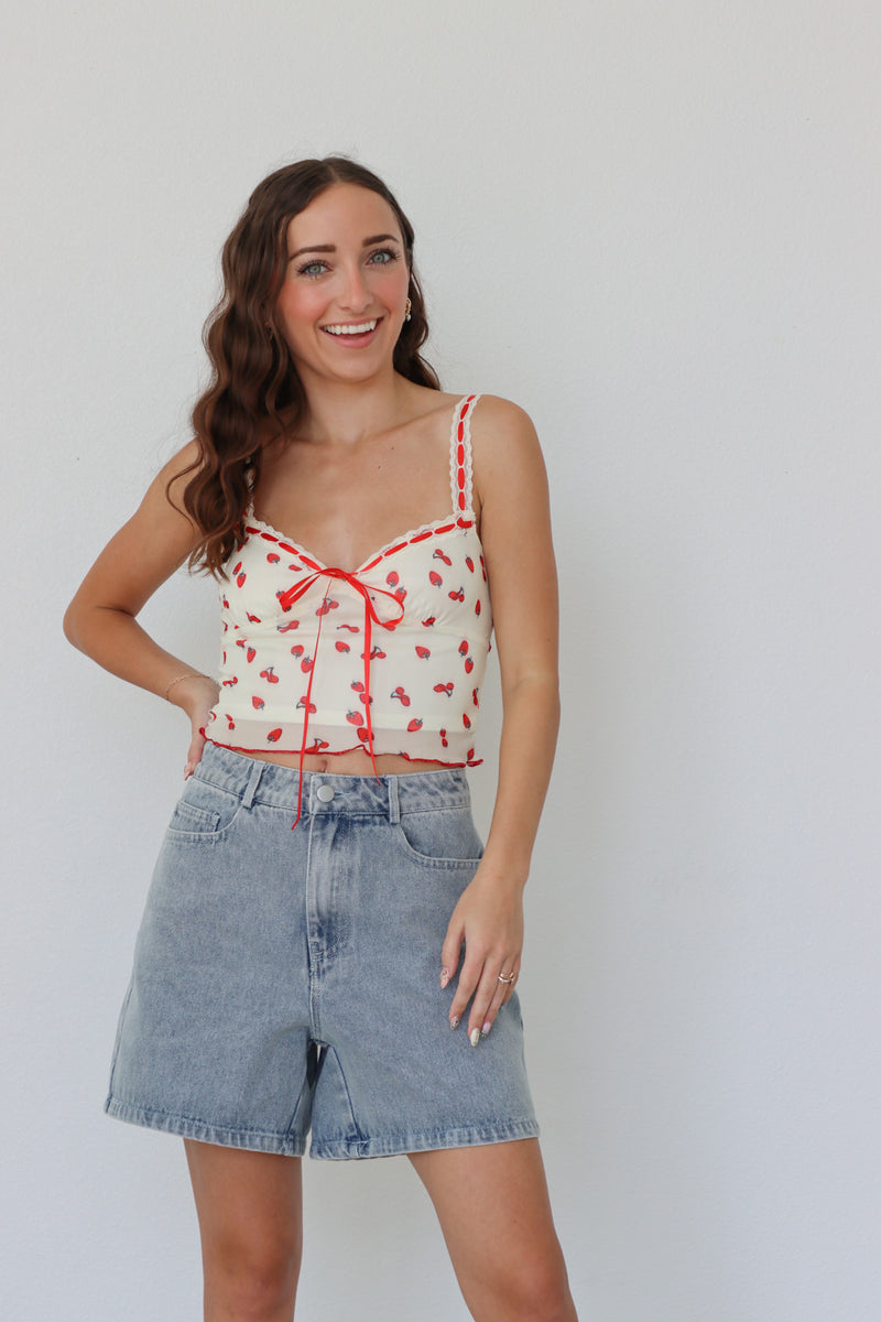 girl wearing cream and red top with strawberry print