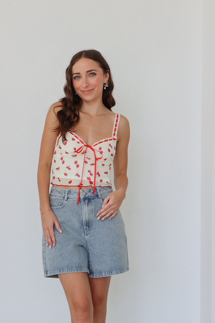 girl wearing cream and red top with strawberry print