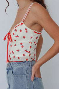 girl wearing cream and red top with strawberry print