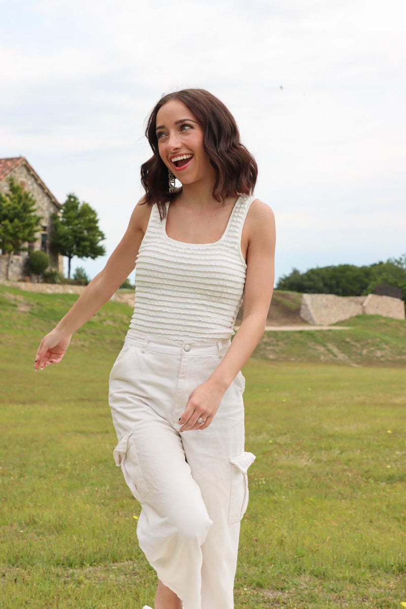 girl wearing white ruffle tank top bodysuit