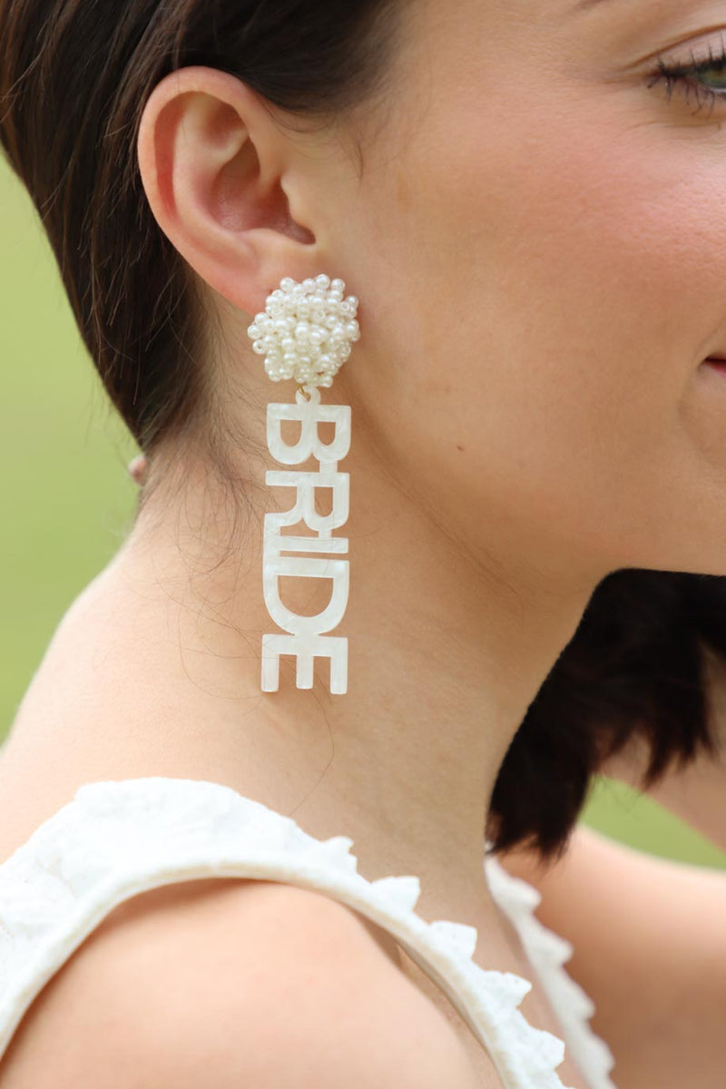 girl wearing white "bride" earrings 