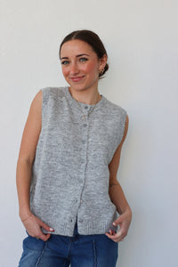 girl wearing grey knit sleeveless cardigan top