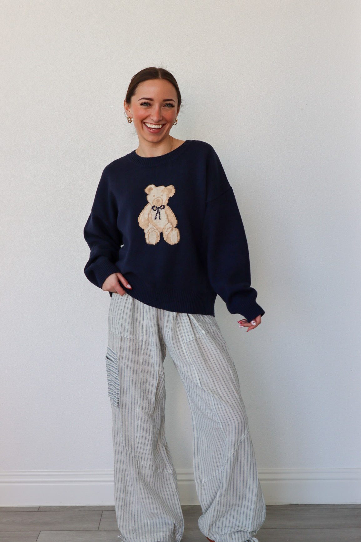 girl wearing navy teddy bear knit sweater