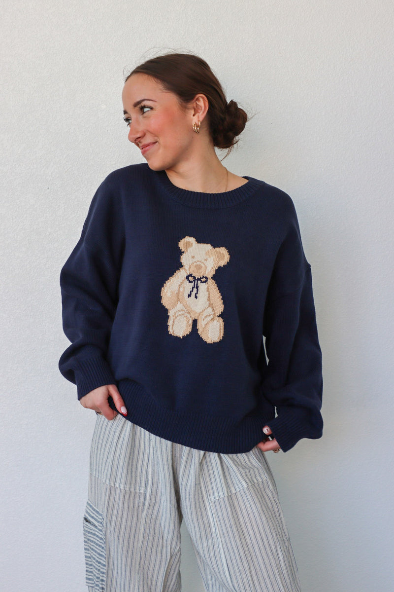 girl wearing navy teddy bear knit sweater