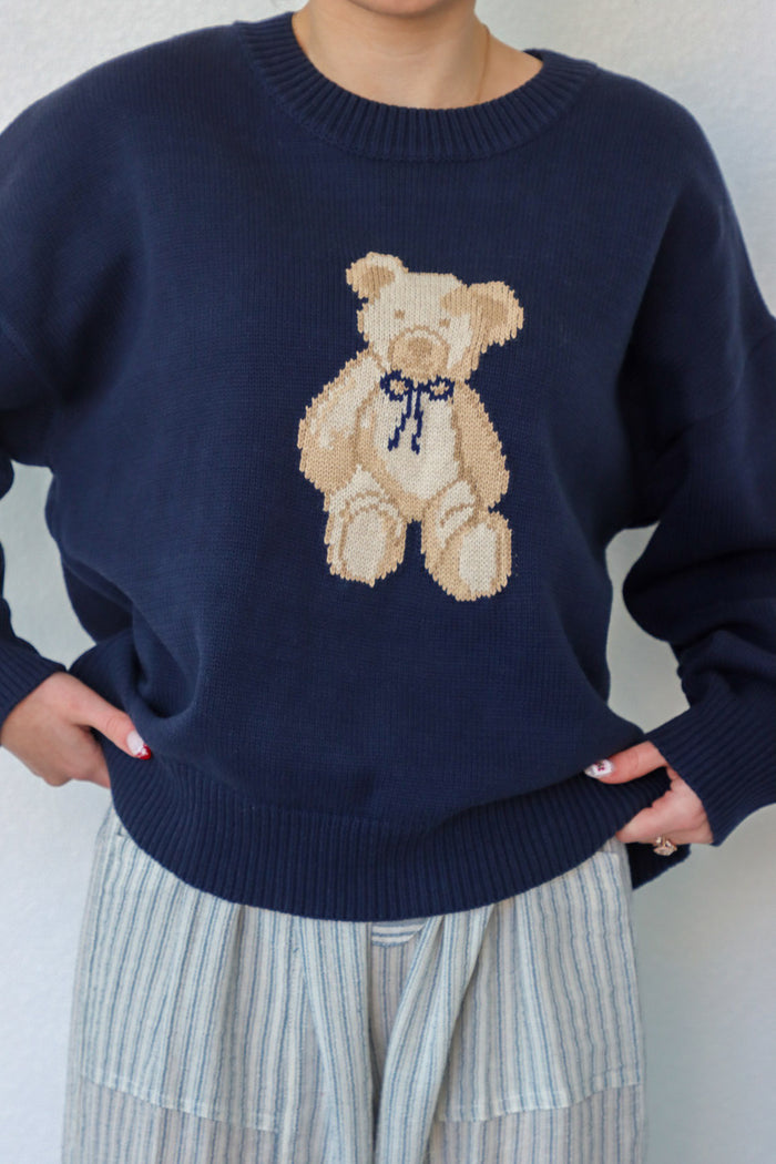 girl wearing navy teddy bear knit sweater