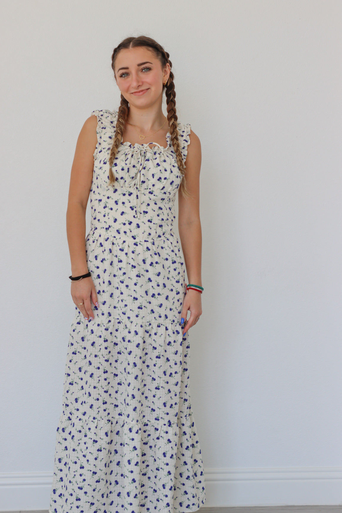 girl wearing white long peasant dress with blue floral pattern