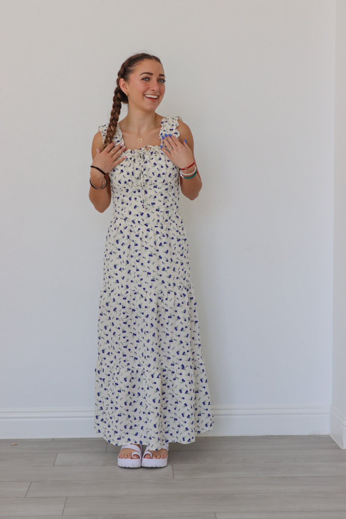 girl wearing white long peasant dress with blue floral pattern