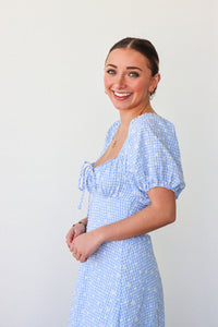 Woman wearing a blue checkered dress against a white background