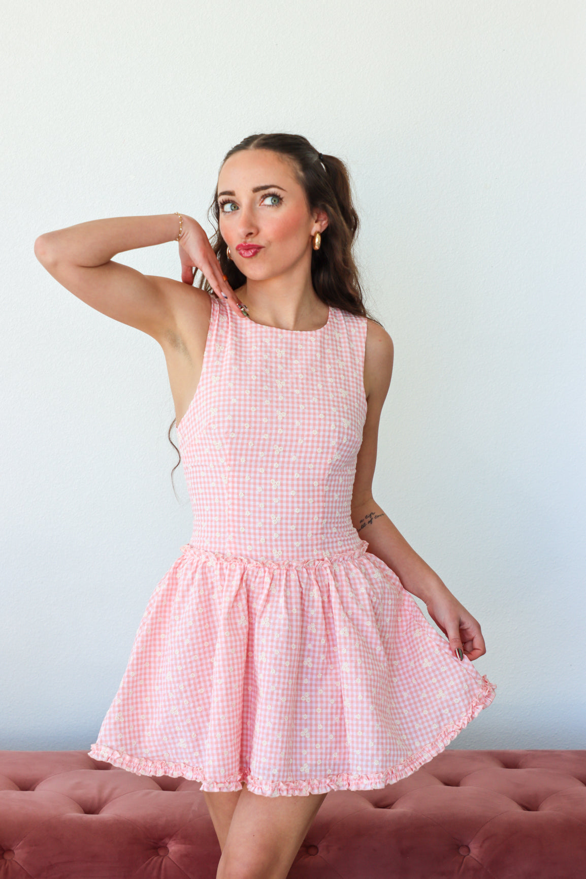 Woman wearing a pink checkered dress against a white background