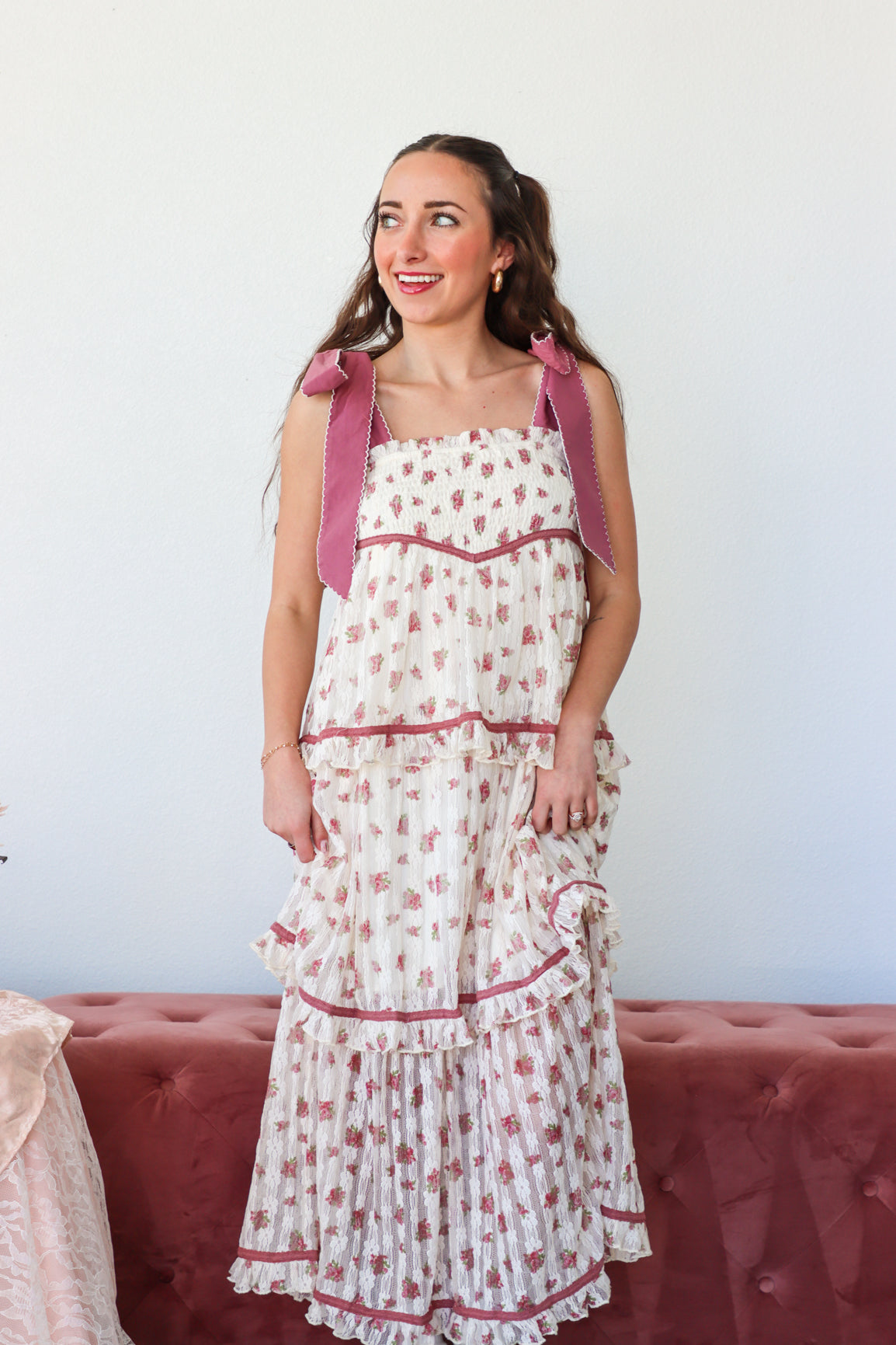Woman wearing a floral dress with pink accents against a white background