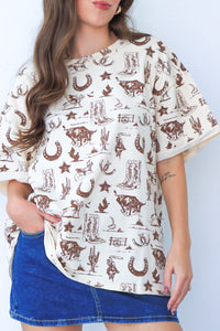 Woman wearing a white blouse with brown western pattern and a blue denim skirt against a white background