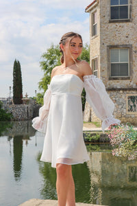 girl wearing wearing strapless white dress with tulle long sleeves