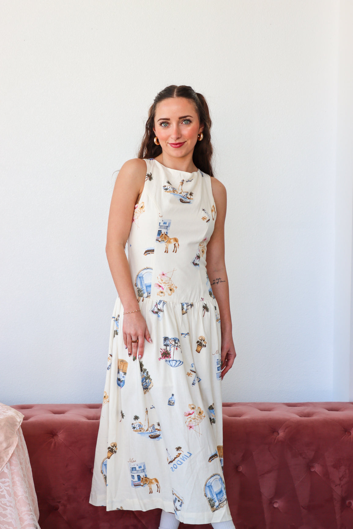 Woman wearing a white dress with animal prints against a plain background