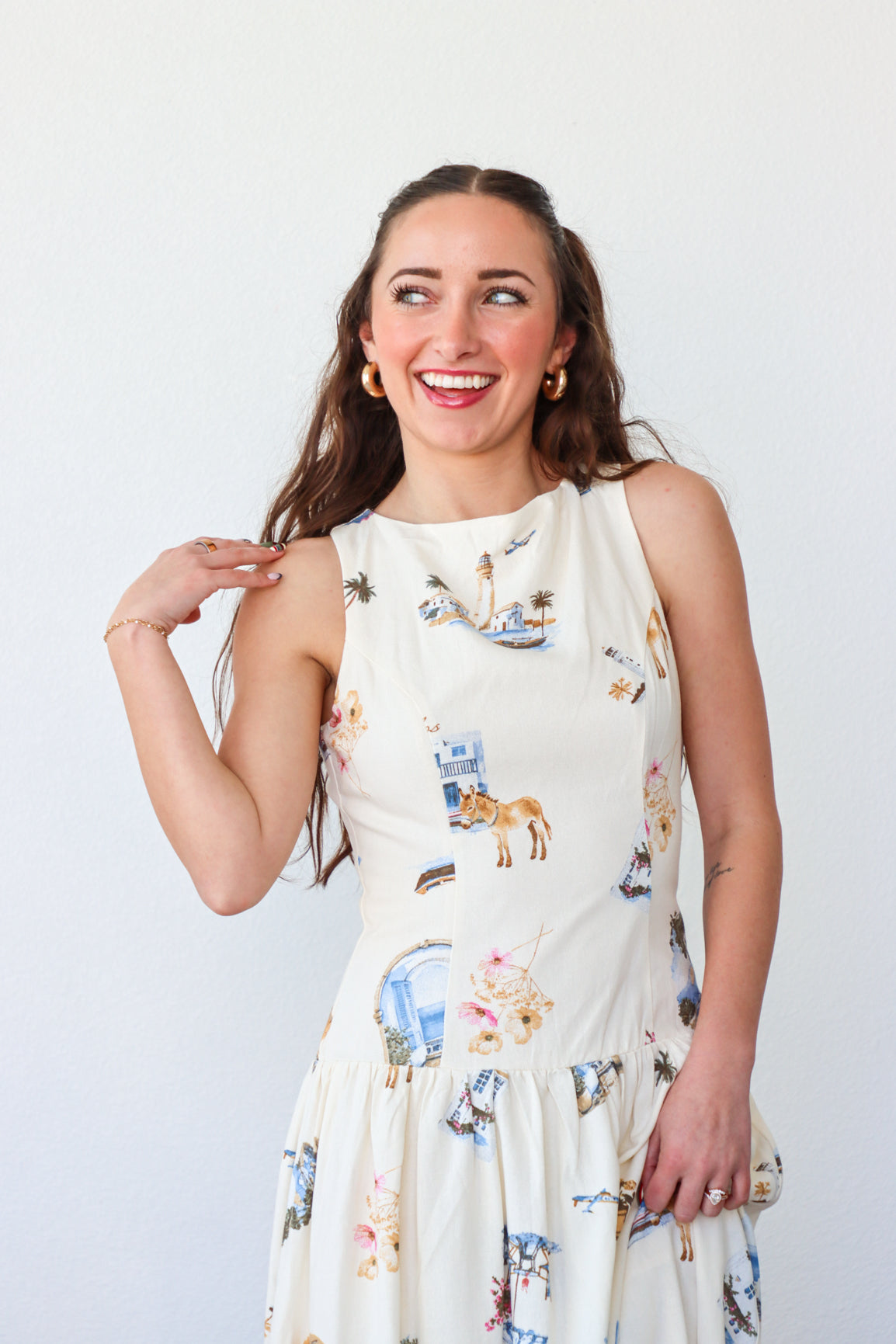 Woman wearing a white dress with animal prints against a plain background