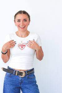 Woman wearing a white t-shirt with a red graphic design on a plain background