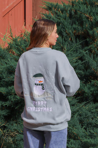 girl wearing light blue snowman crewneck