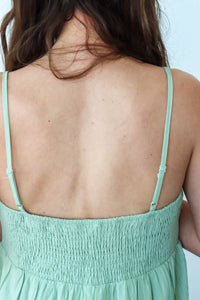 Mint green dress with thin straps on a plain background