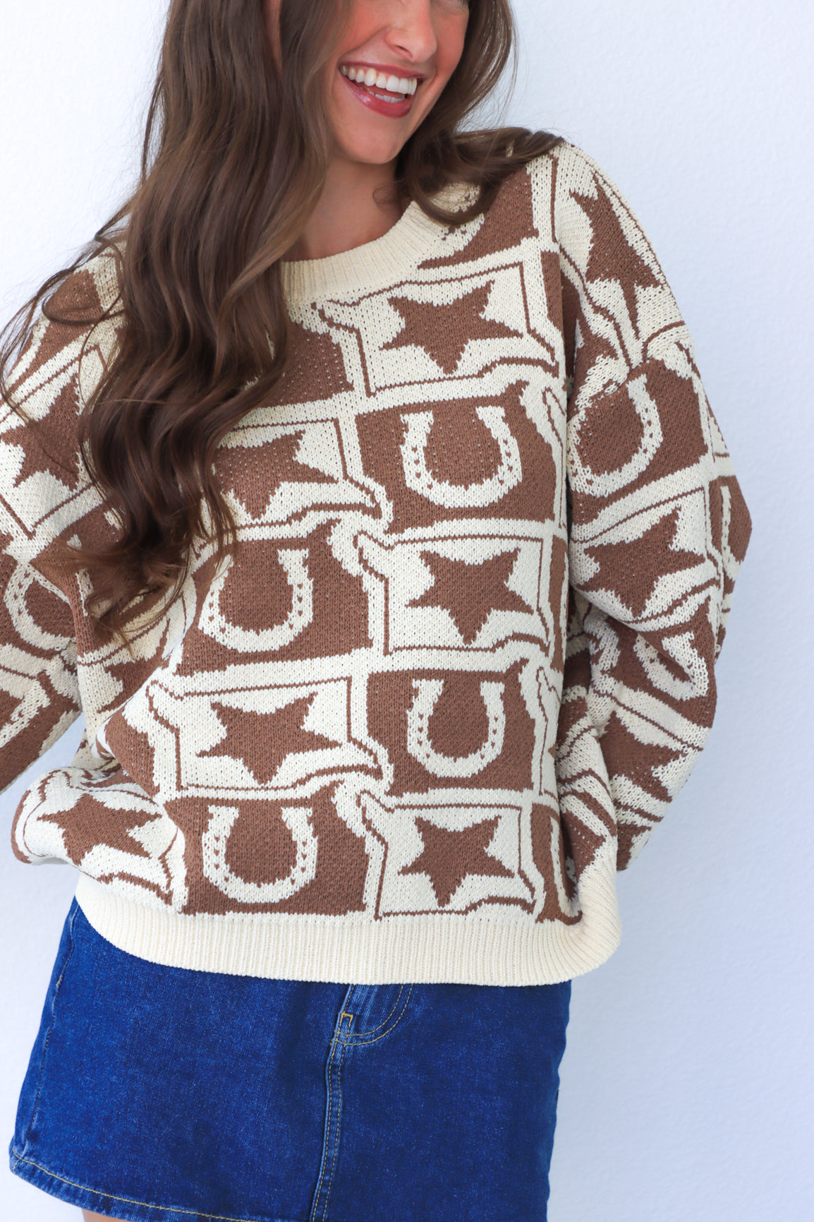 Person wearing a brown and beige patterned sweater with a white background