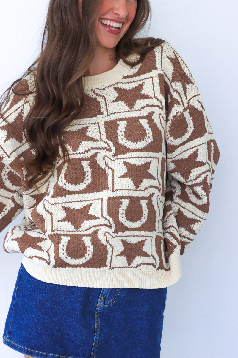 Person wearing a brown and beige patterned sweater with a white background