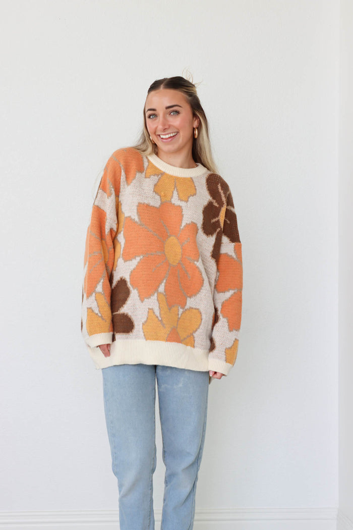 girl wearing brown and orange floral sweater