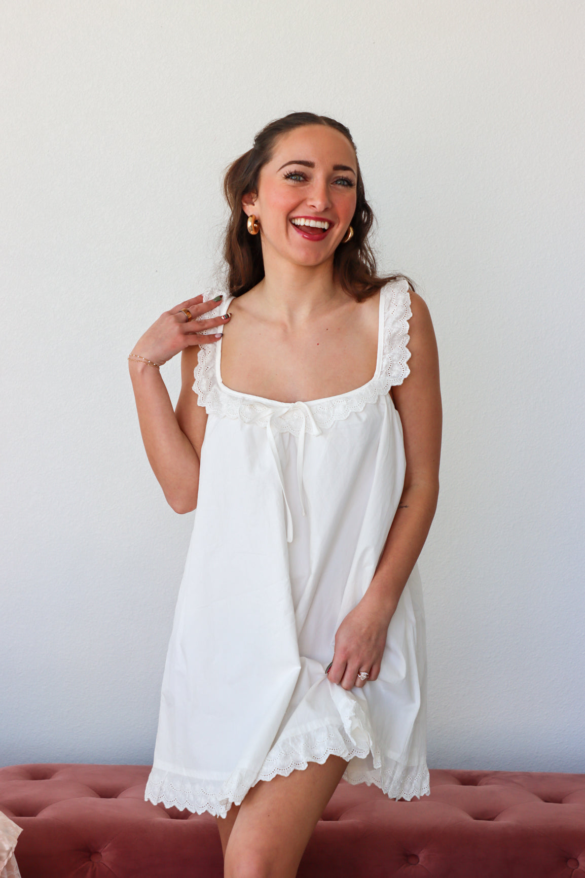 Woman wearing a white lace nightgown against a plain background