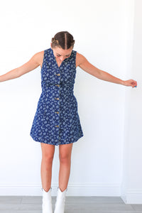 Woman wearing a blue floral dress against a white background
