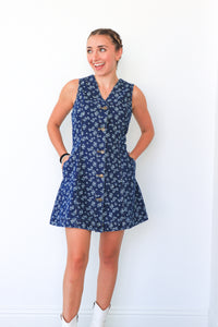 Woman wearing a blue floral dress against a white background
