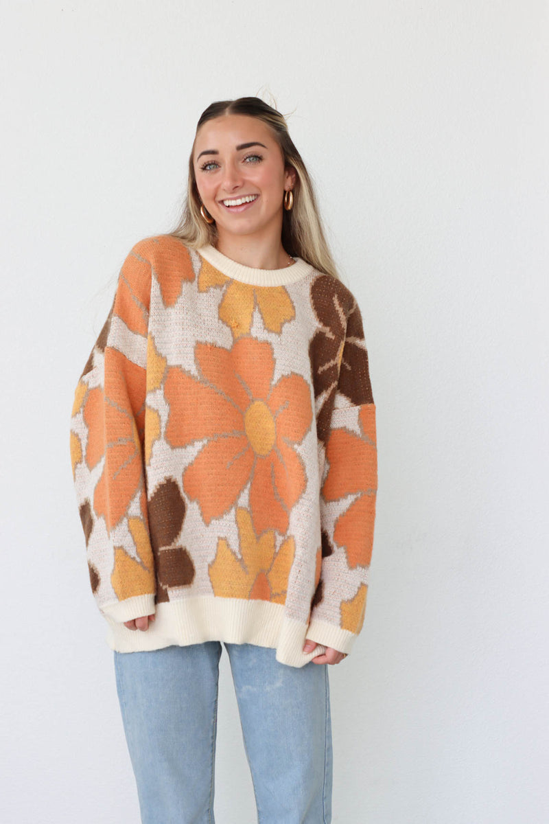girl wearing brown and orange floral sweater